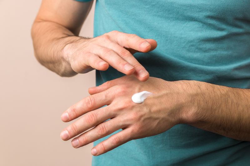 Das erste Mittel der Wahl gegen rissige Hände ist die Handcreme. Mit rückfettenden Stoffen wie Sheabutter, Urea oder Mandelöl spendet sie Ihrer Haut Feuchtigkeit und stärkt die Hautbarriere. Sie sollten Ihre Hände pro Tag zweimal und nach jedem Waschen eincremen. Bei stark angegriffenen Händen können Sie die Creme dick auftragen und unter Baumwollhandschuhen einwirken lassen.
