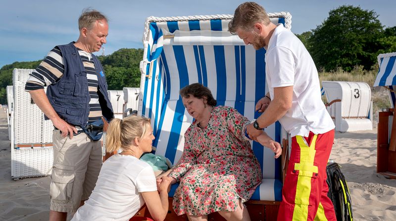 Nora Kaminski (Tanja Wedhorn, zweite von links) und Rettungssanitäter Lars Hinrichs (Bo Hansen, rechts) werden zum Strand gerufen: Doris Hebestreit (Swetlana Schönfeld) geht es nicht gut.