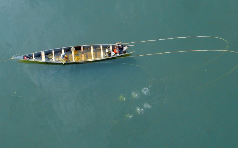 Am Volta-Fluss in Ghana tauchen die Menschen auf der Suche nach Muscheln.