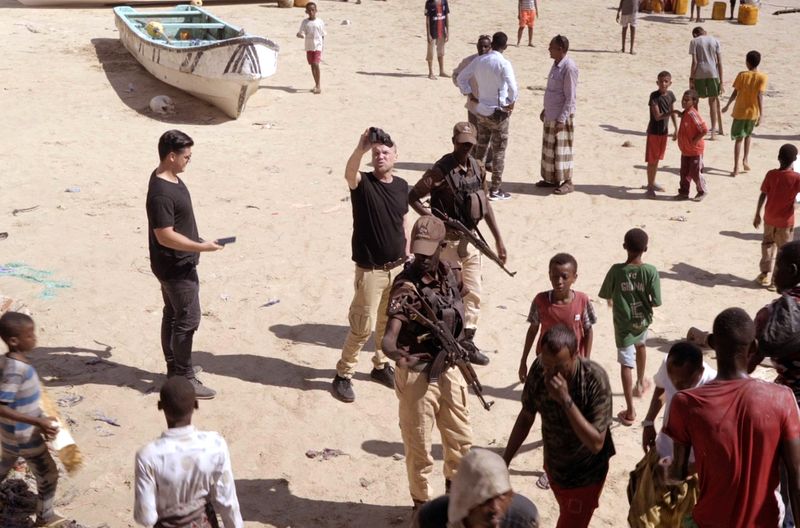 Die Kriegstouristen Andrew und AJ werden in Somalia am Strand von privaten Bodyguards bewacht.