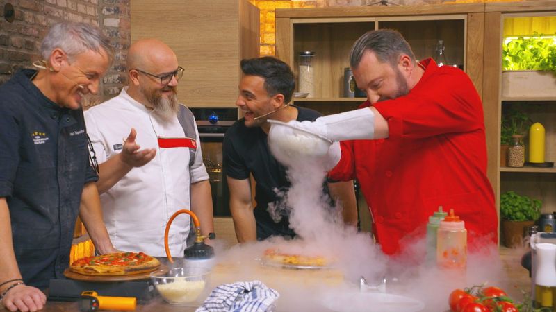 Achtung, der Mann mit den Sicherheitshandschuhen kommt. Sebastian Lege (rechts) verteilt Büffel-Mozzarella-Staub über seiner Pizza. Das Geheimnis: Der Käse wurde zuvor schockgefrostet - im Stickstoff-Bad mit minus 200 Grad.