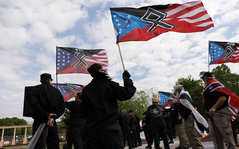 Neonazis bei einer Demo 2018 in Georgia mit Nationalisten-Fahnen, die an die Kreuze der Konföderalisten und des Ku-Klux-Klan angelehnt sind. Kurz zuvor war es in Charlottesville zu Kämpfen zwischen Rassisten und Antirassisten gekommen.