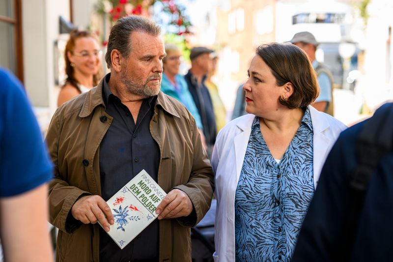 Erwischt! Die Apotheken-Mitarbeiterin Melanie Harms (Tina Pfurr) hat Hauptkommissar Jan Brockhorst (Felix Vörtler) in der Schlange von wartenden Fans des Krimiautors Onneken gesichtet und zieht den Krimi-Fan mit seiner heimlichen Leidenschaft auf. 