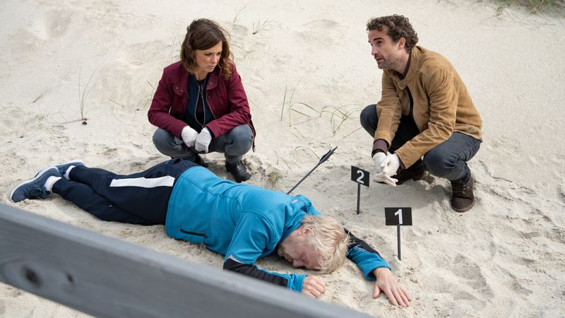 Hinnerk Feldmann (Oliver Wnuk) und Ina Behrendsen (Julia Brendler) untersuchen ihren Tatort am Strand. Hier wurde der Kriminalschriftsteller Leif Conradi (Rolf Jöns) mit Pfeil und Bogen erlegt. Dass dies gar nicht so einfach ist, finden die Kriminaler bald heraus.