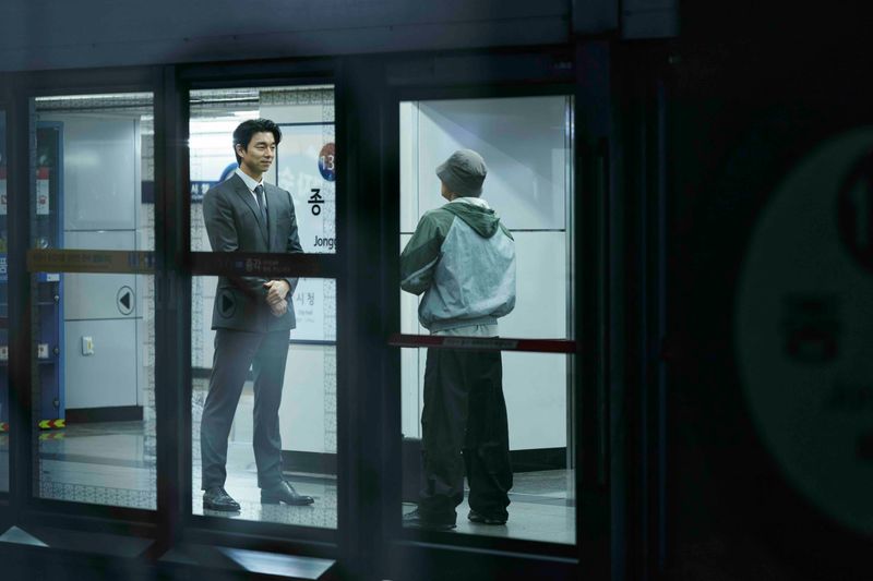 Der geheimnisvolle Mann im Anzug (Gong Yoo, links) wirbt in der U-Bahn Seouls wieder Menschen für ein neues Spiel an.