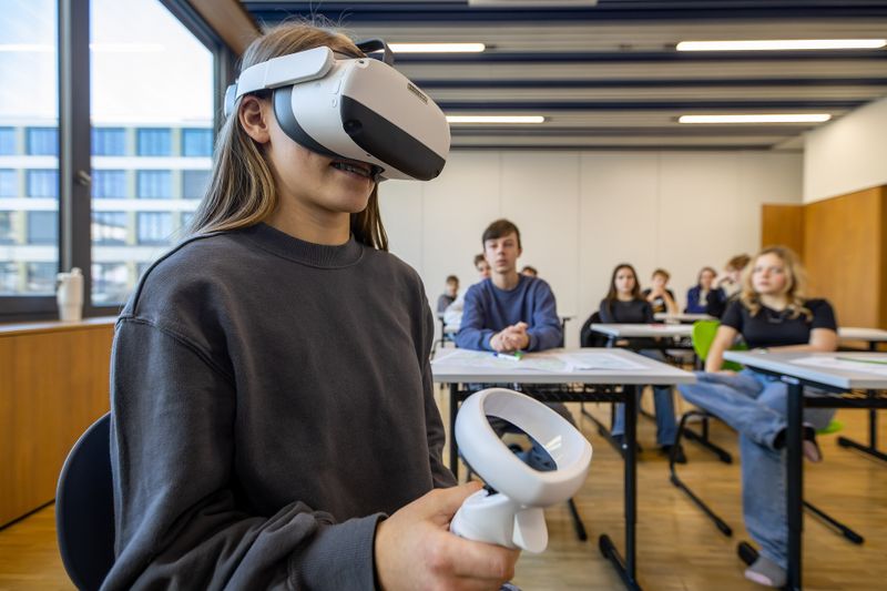 Eine Schülerin simuliert gefährliche Situationen im Straßenverkehr mit einer VR-Brille.